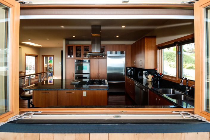 A photo looking through the kitchen window of the sunset view home in white rock bc as built by surfside construction inc.