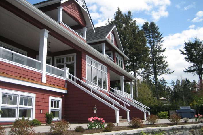 A photo of a shingle-style estate showing the back of the home from another angle.