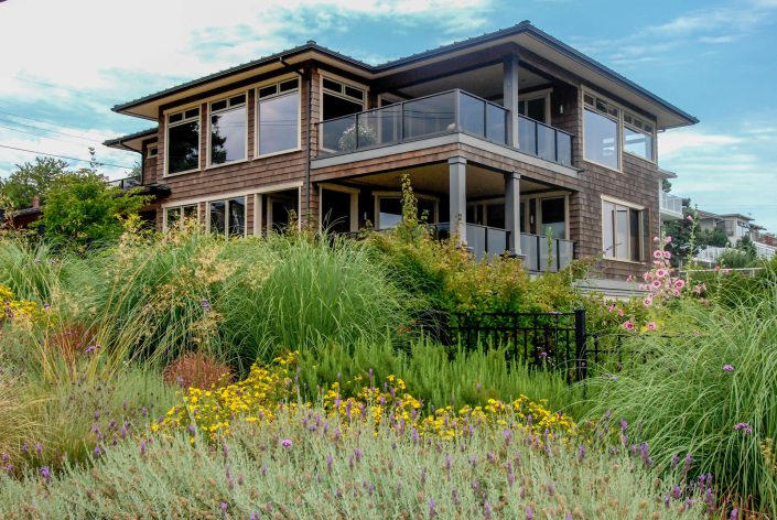 A photo of the back of a cedar shake hill side estate built by Surfside Construction.