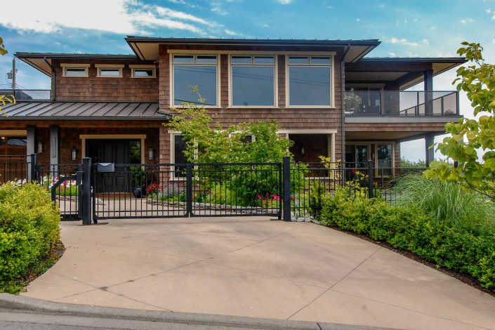 A photo of the front of a cedar shake hill side estate built by Surfside Construction.