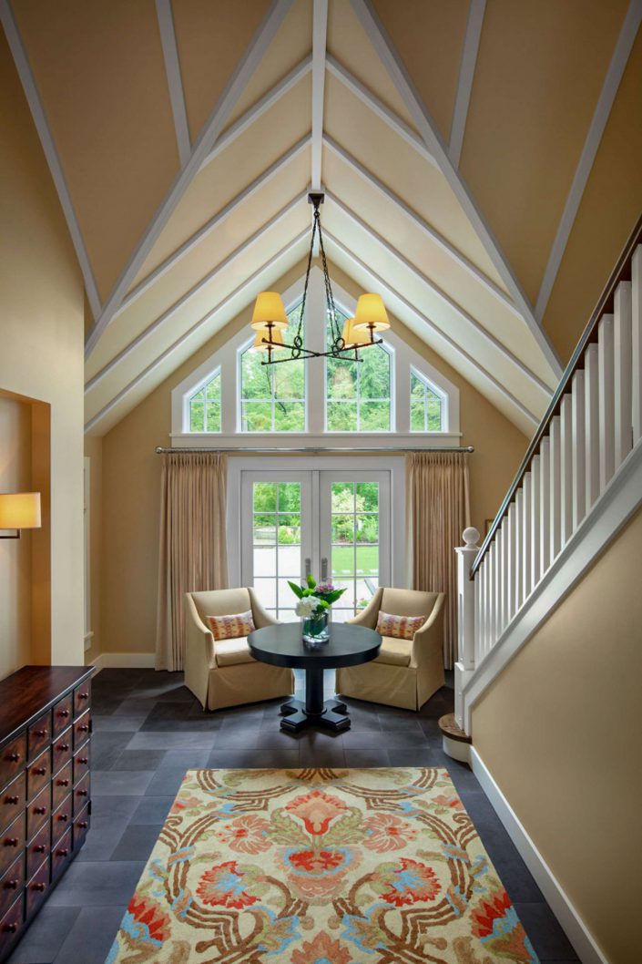an interior photo of the stairway, vaulted ceiling and exit doors to the backyard of the country classic home built by surfside construction inc.