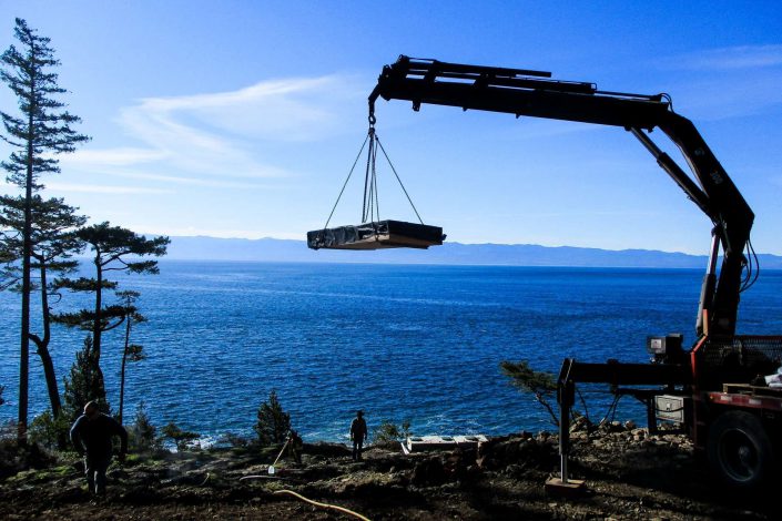 A photo of lumber being delivered to the lighthouse home in the sooke bc as built by surfside construction inc.