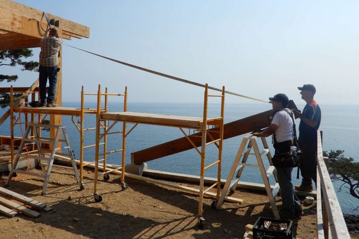a Photo of Owen and crew raising a beam in the lighthouse home in the sooke bc as built by surfside construction inc.