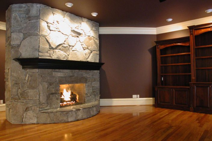 a photo of the stone fireplace in the family room of the victorian replica home as built by surfside construction inc.