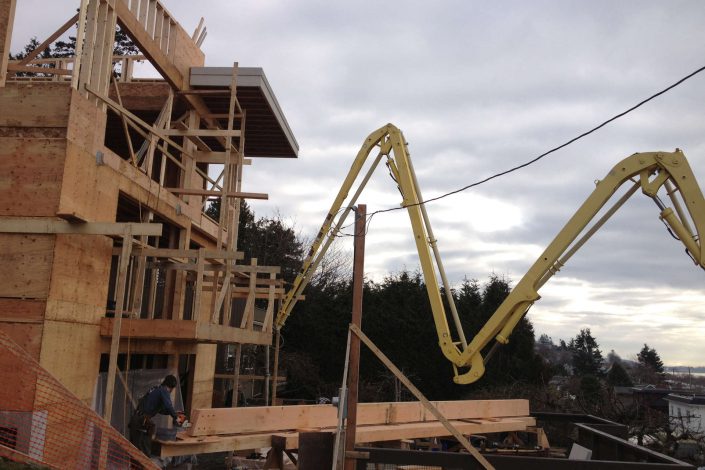a photo of the concrete pump trucks boom being used to pump concrete in the west beach home as built by surfside construction inc.