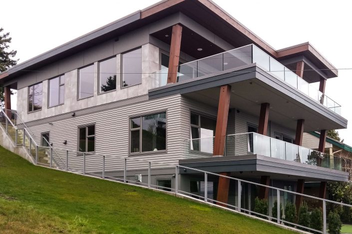 An exterior photo of the hillside modern home showing the three stories and decks as built by surfside construction inc.