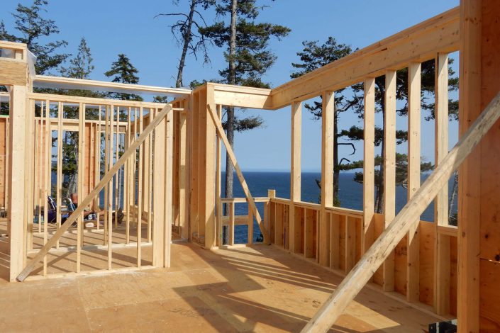 A photo looking through the framing of the view of the ocean in the lighthouse home in sooke bc as built by surfside construction inc.