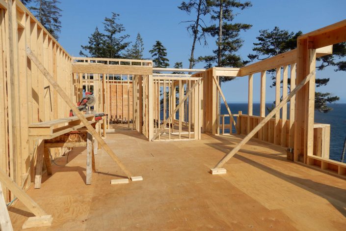 A photo of the lighthouse home during framing and the view of the ocean in sooke BC as built by surfside construction inc.