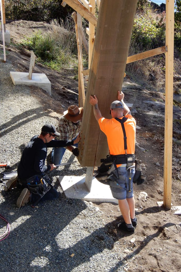 Another image of Owen and the crew placing a large support beam in the lighthouse home in sooke bc.