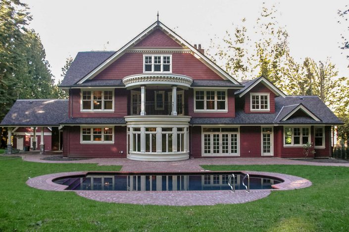 A photo of the back of the victorian replica home showing the large bow window and pool as built by surfside construction inc.
