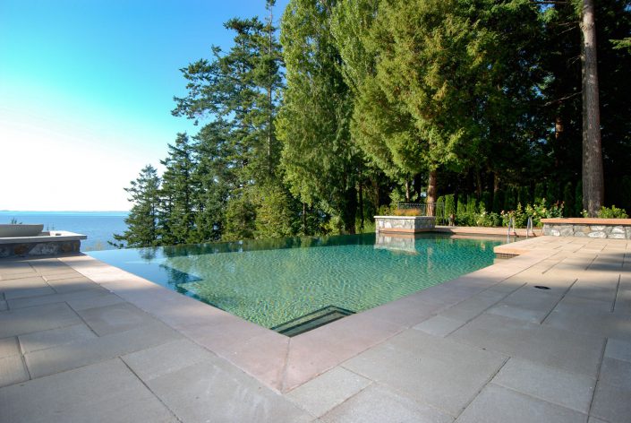 A photo looking out over the infinity pool and ocean from the crescent bluff home as built by surfside construction inc.