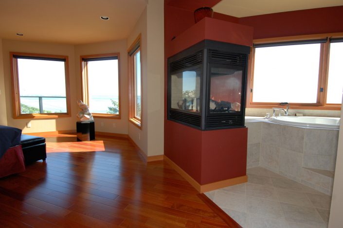 A photo of the fireplace and soaker tub in the master bedroom of the sunset view home in white rock bc as built by surfside construction inc.