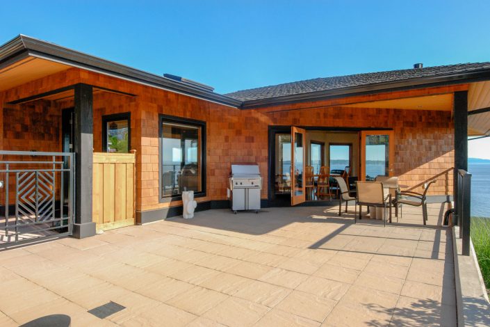 An exterior view of the patio and deck of the sunset view home as built by surfside construction inc.